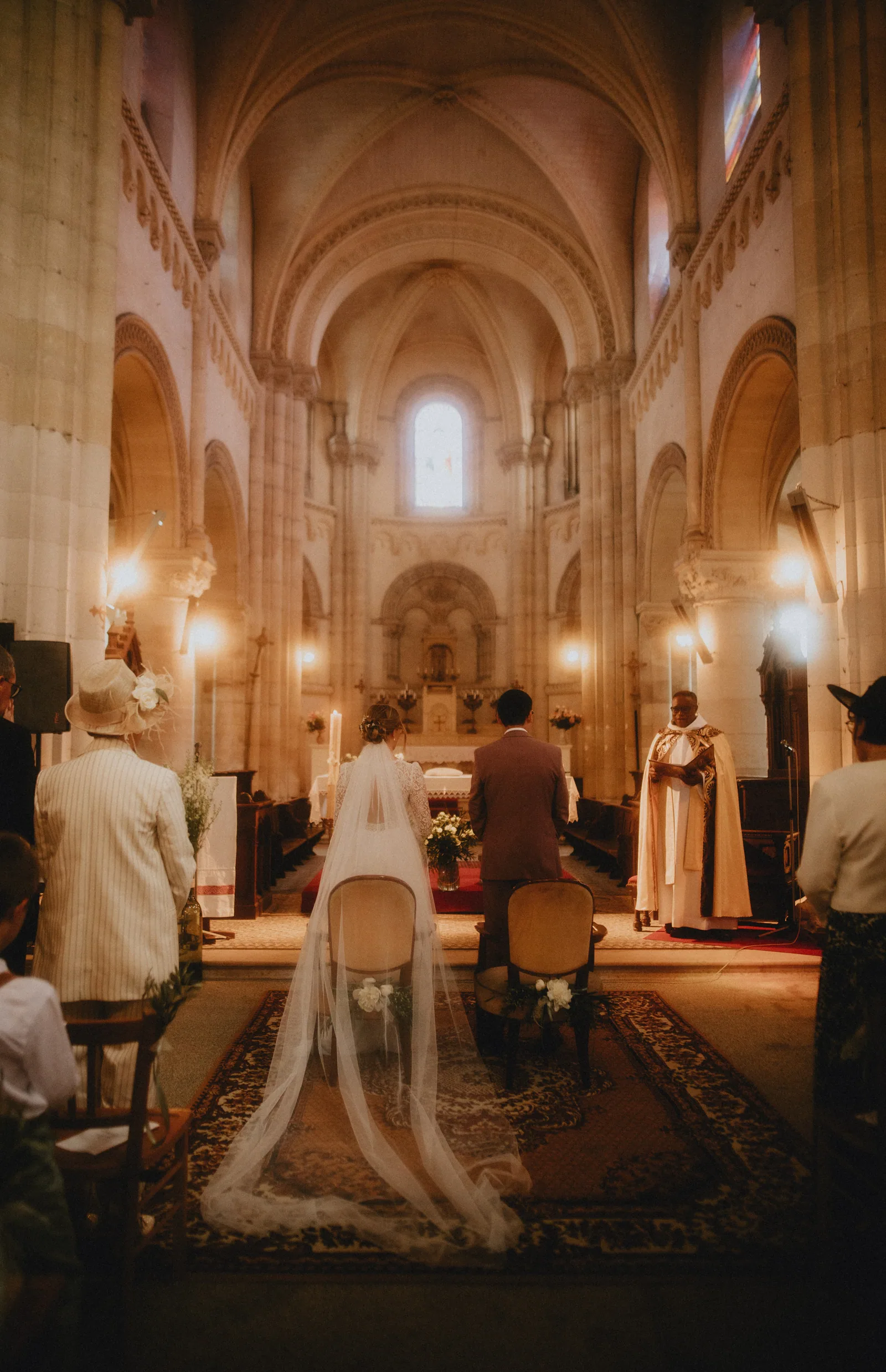 Cérémonie à l'église, long voile de la mariée déployé dans l'allée