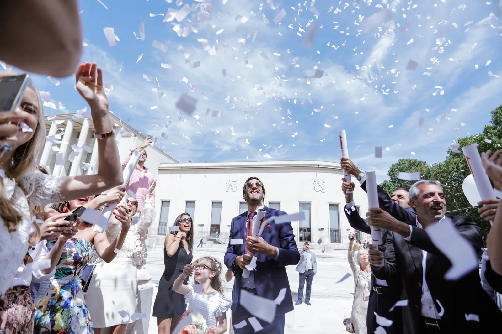 Lancer de confettis à la sortie des mariés devant un bâtiment officiel