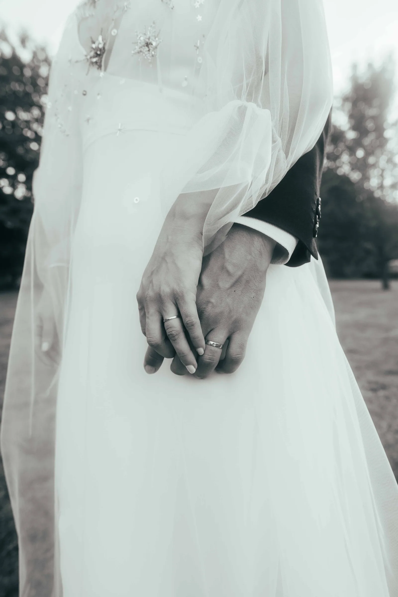 Main du marié sur la taille de la mariée à travers le voile, noir et blanc