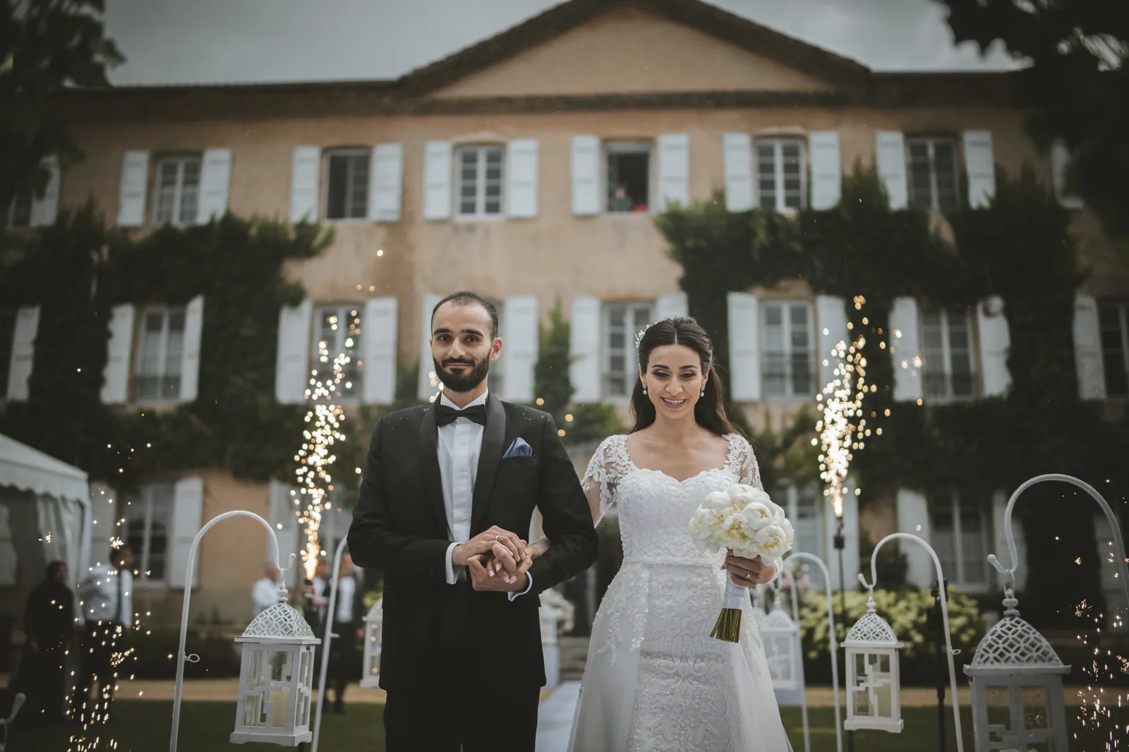 Les mariés entre deux fontaines d'étincelles devant le château