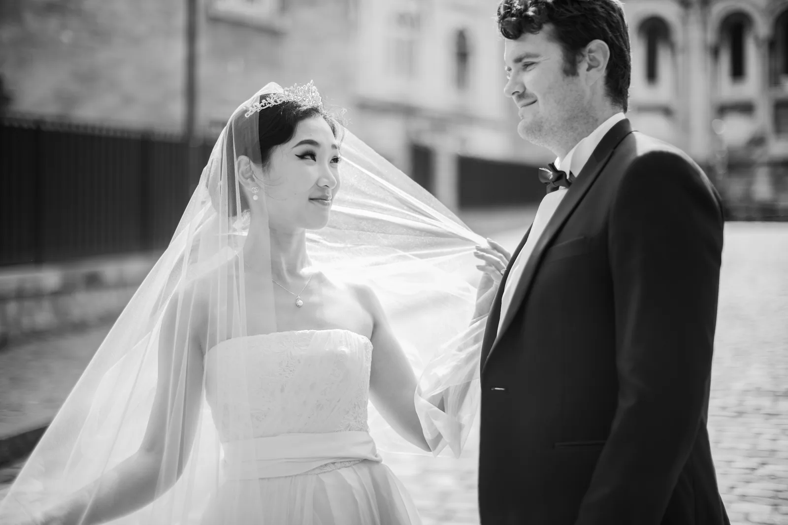 Les mariés rient sous le voile, photo en noir et blanc